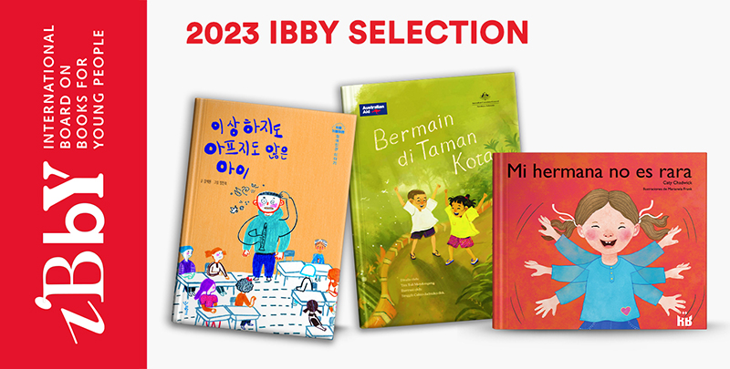 red spine of the 2023 IBBY catalogue 3 book covers Isanghajido apeujido anh-eun ai (A child who is neither strange nor sick), Bermain di Taman Kota (Playing in the city park), Mi hermana no es rara (My sister is not weird)