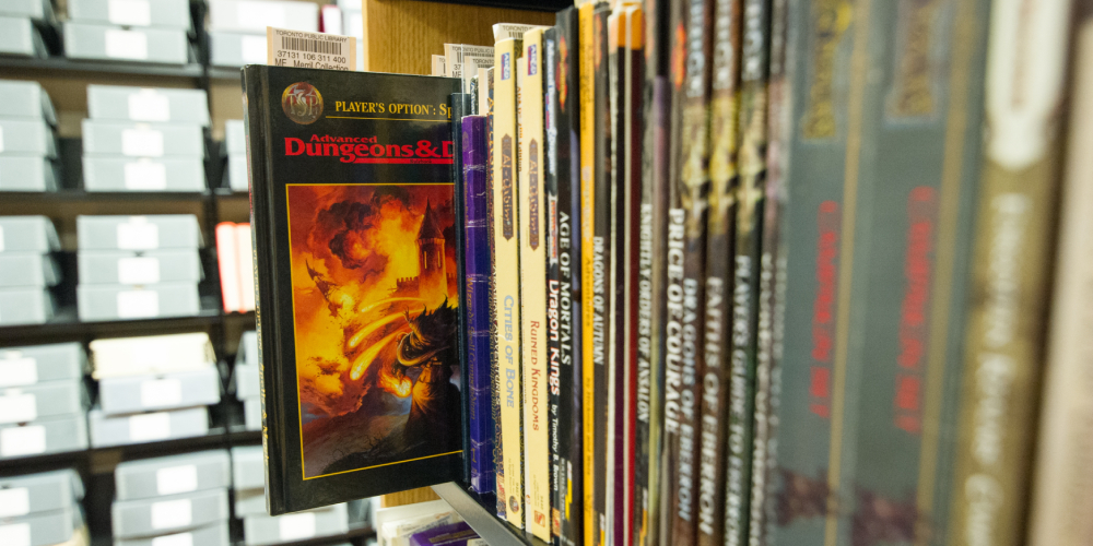Archival boxes behind shelf of books with Dungeons and Dragons cover sticking out