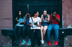 Young adults sitting holding cameras