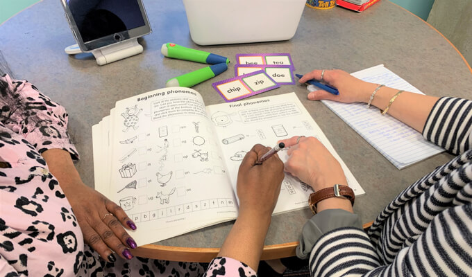 A learner and volunteer work together on literacy activities.