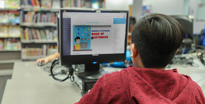 Boy using the library’s computer to do his homework