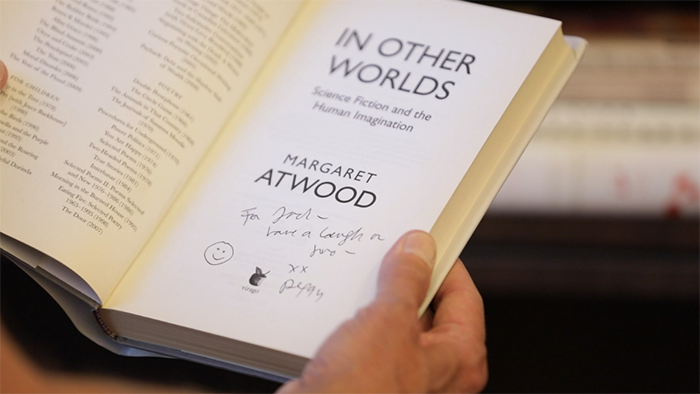 Hands holding a signed book, In Other Worlds, by Margaret Atwood