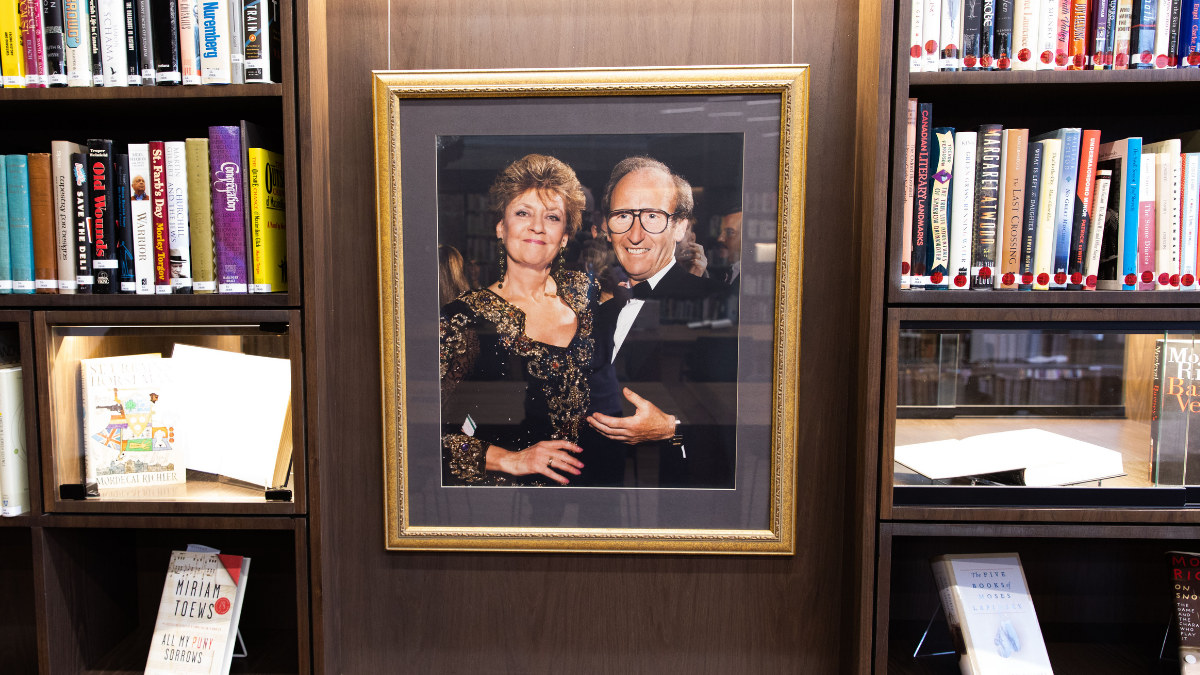 A close-up look at bookshelves and memorabilia displayed in the Jack Rabinovitch Reading Room, including a framed photo of Doris and Jack Rabinovitch.